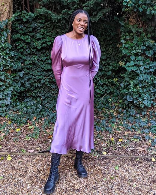 A women styled in a purple dress with Dr. Martens boots