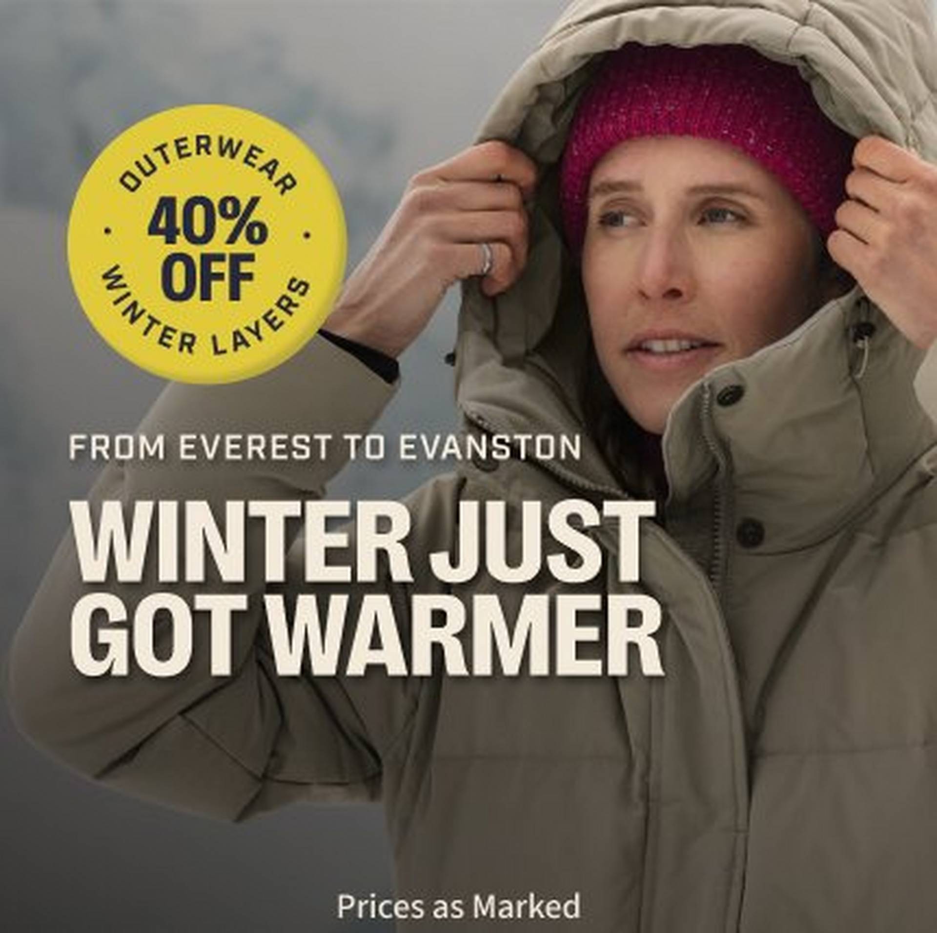 Woman wearing a tan parka with hood up.