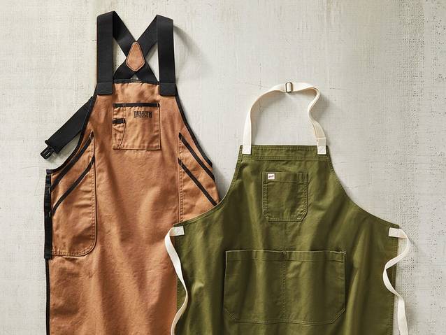 two duluth aprons laying on a concrete background