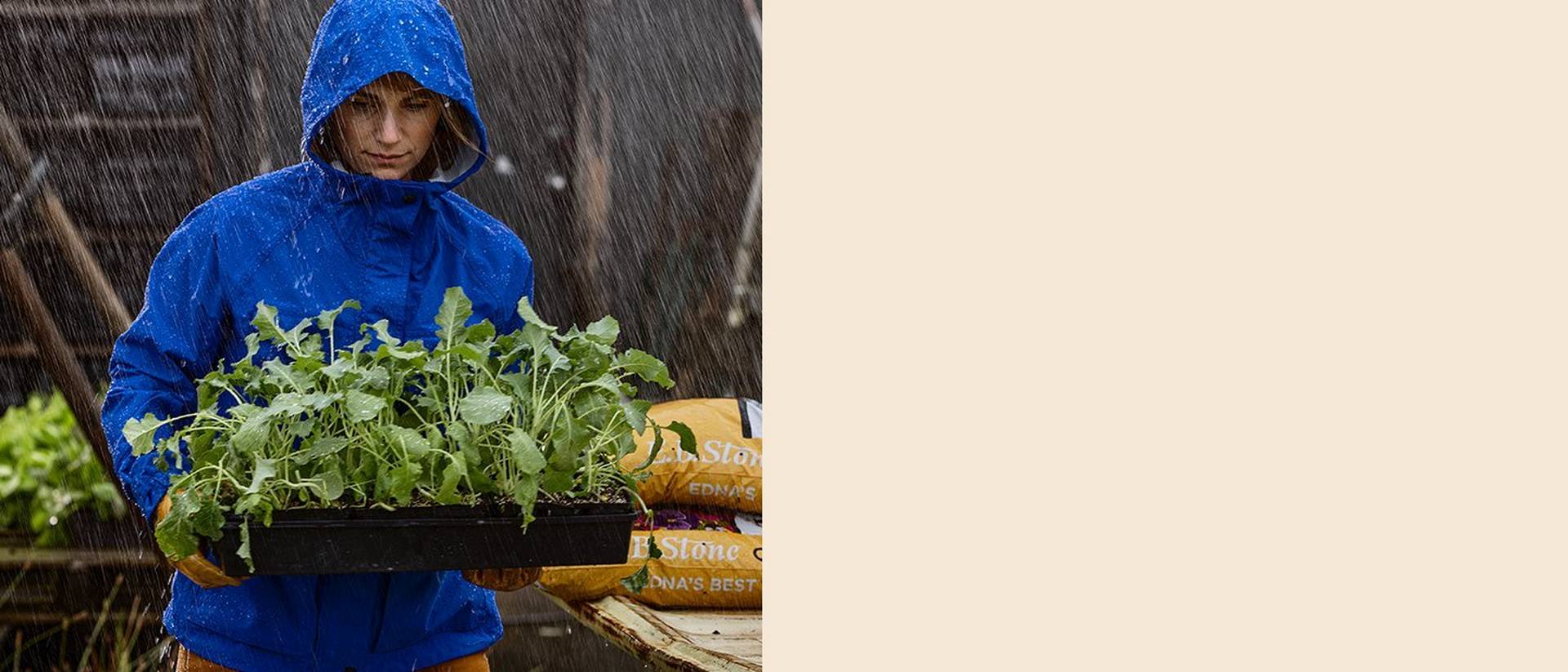 Woman working in a garden with rain coming down; Wearing No-Rainer jacket