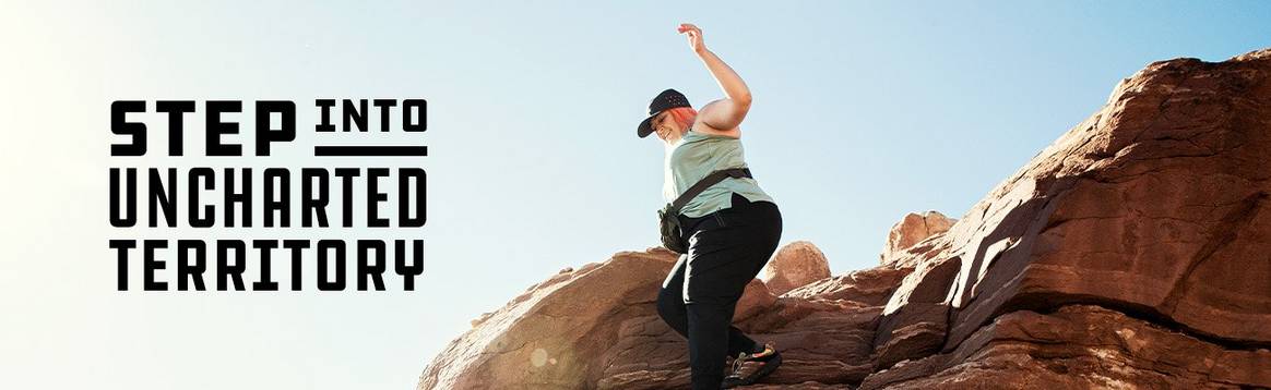 Woman hiking through boulders and rocks in Utah