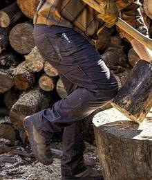 Man wearing navy pant chopping wood