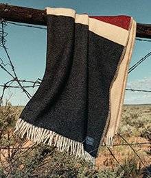 A red, white and blue blanket hangs on a fence