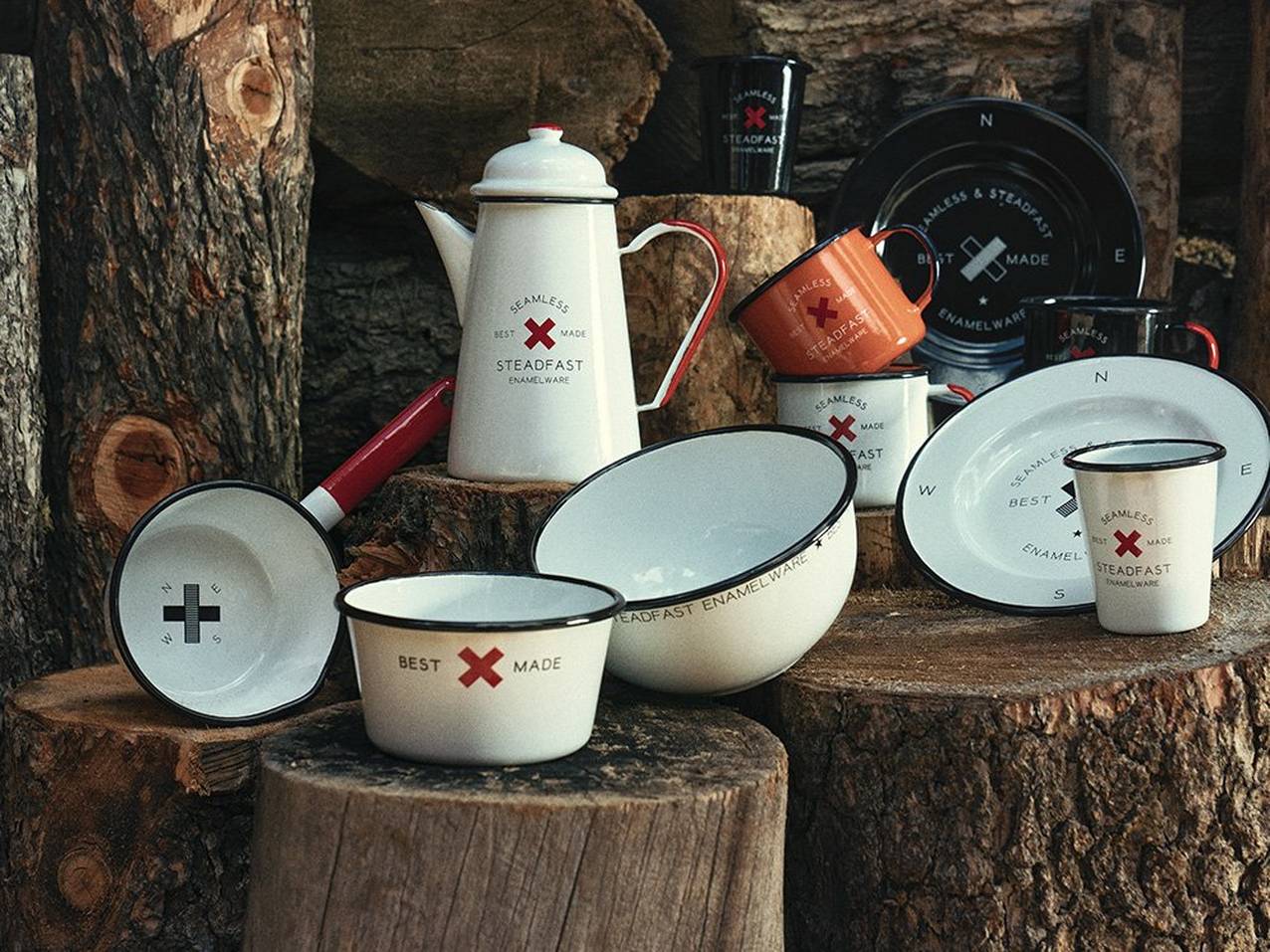 A collection of enamelware arranged on wooden logs