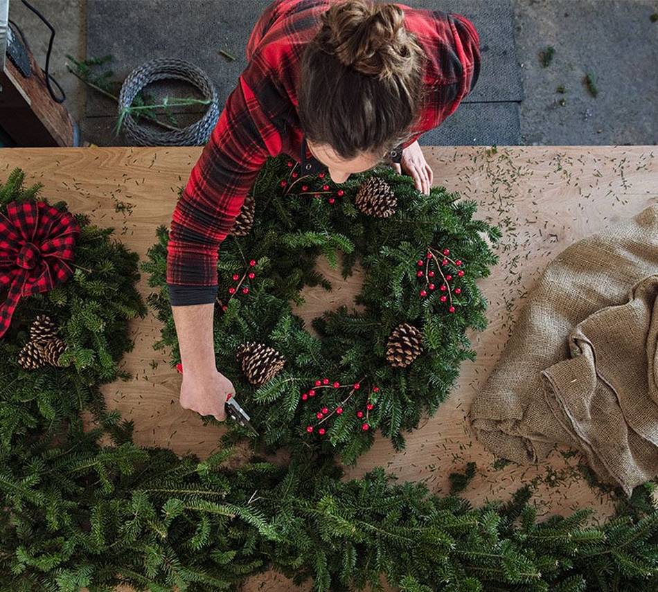 woman in a red flannel creating a wreath