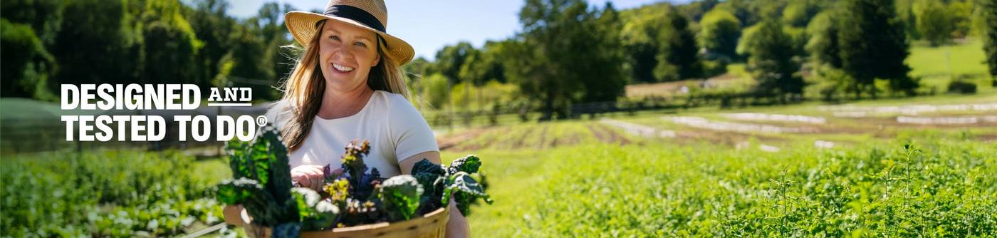 a woman carrying a backet of vegetables in a green field 