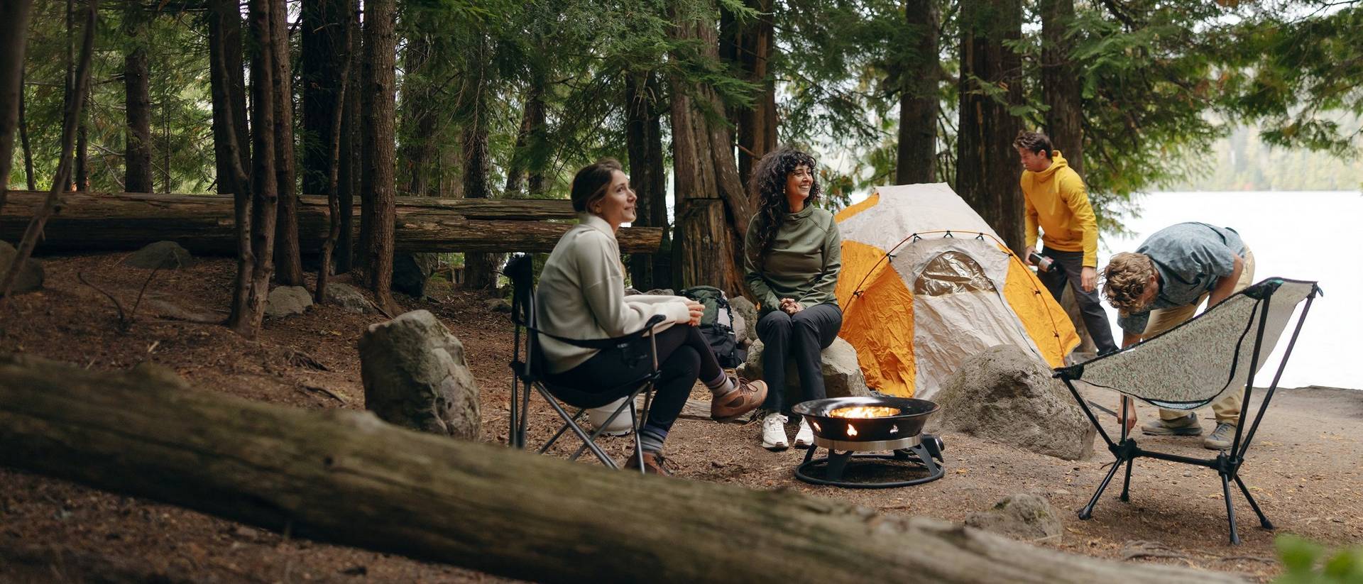 Four people lounging around a campsite.