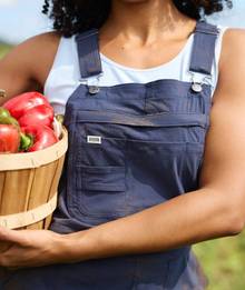 Woman wearing navy blue overalls.
