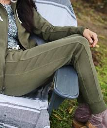 Woman wearing olive green joggers.
