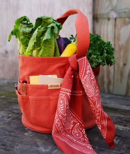 Orange gardening harvest bag with bandana tied around it.
