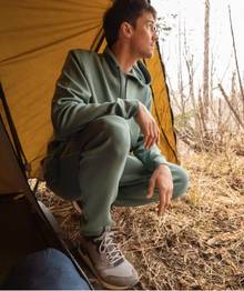 Man crouching in green sweatpants.