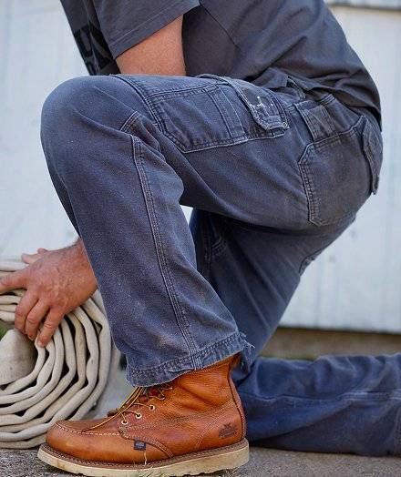 Man crouching in blue work pants.