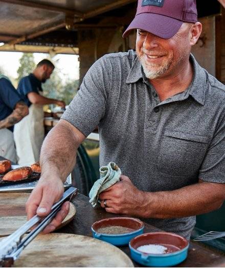 Man wearing a grey polo, grilling.