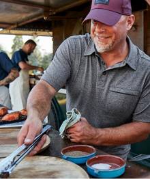Man wearing a grey polo, grilling.