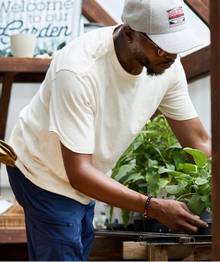 Man wearing a white t-shirt while gardening.
