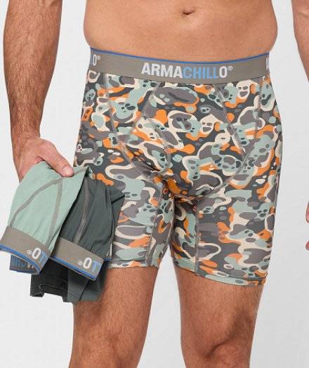 Man wearing boxer briefs, holding two pairs of underwear.