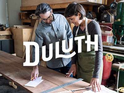 duluth logo over an image of a man and a woman working in a workshop
