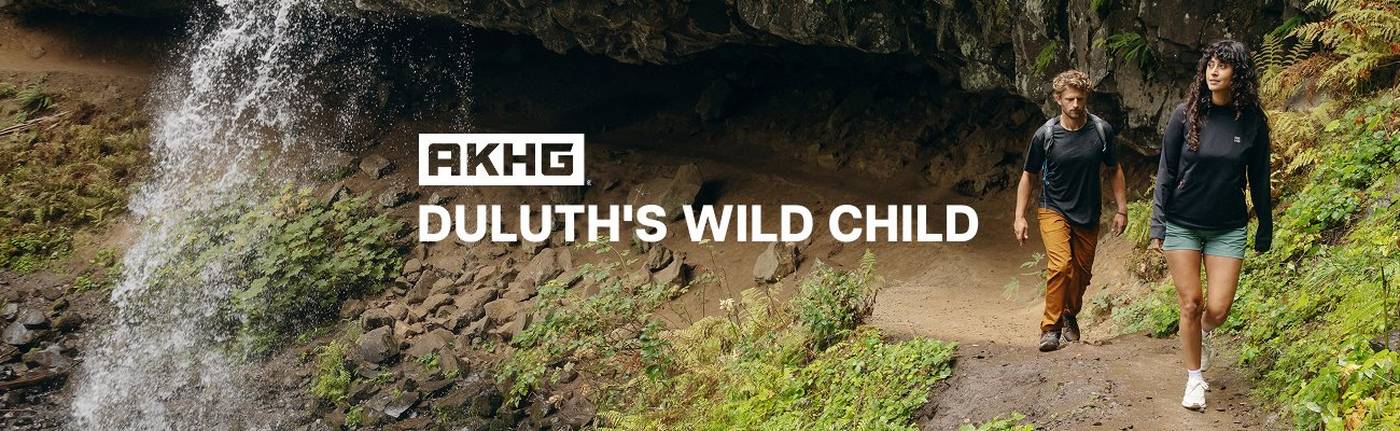 Man and woman hiking near waterfall.