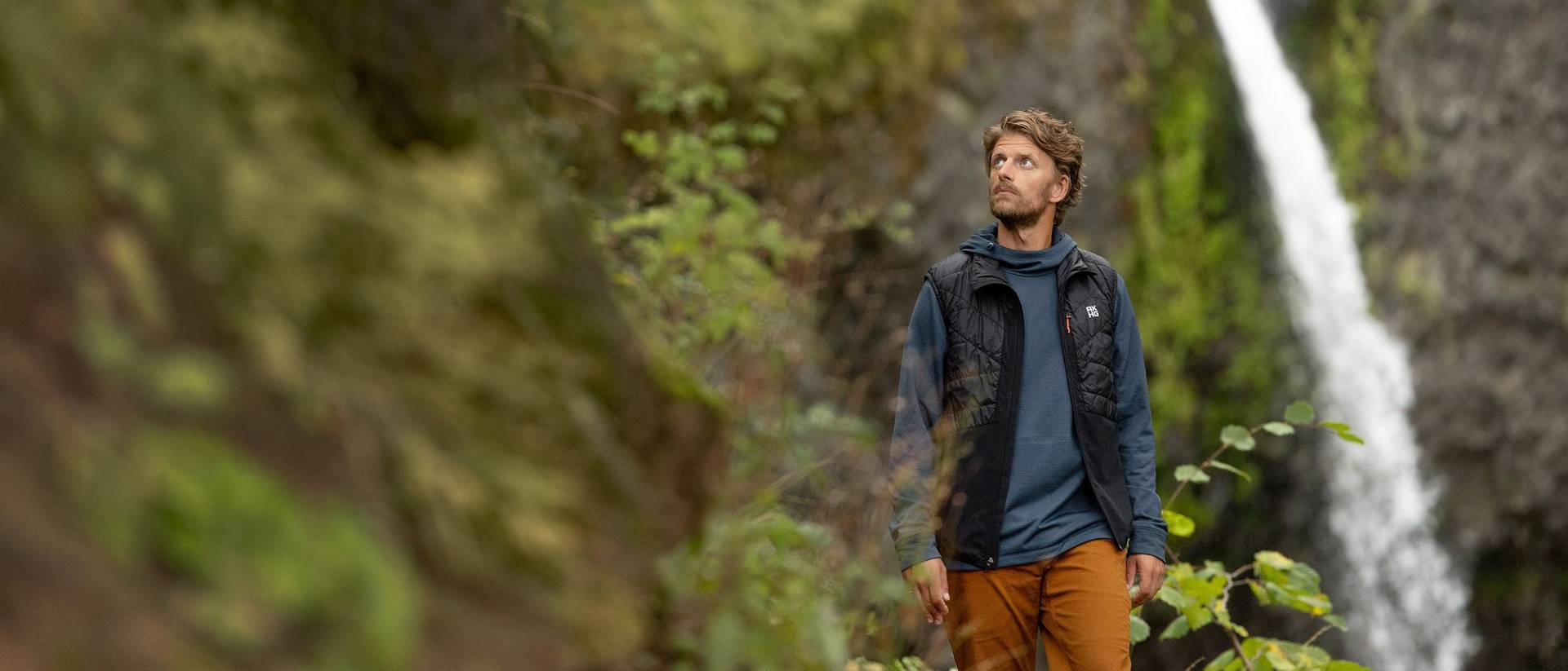 Man hiking near waterfall.