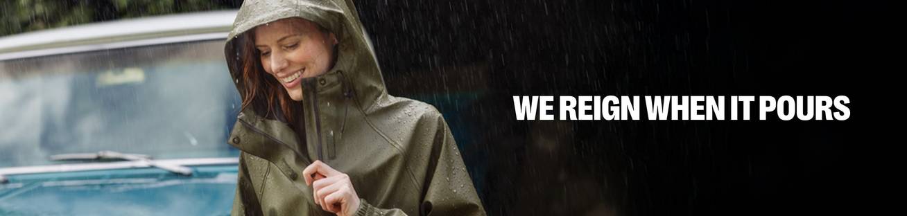 Headline: We Reign When it Pours. A woman in a green rain jacket 