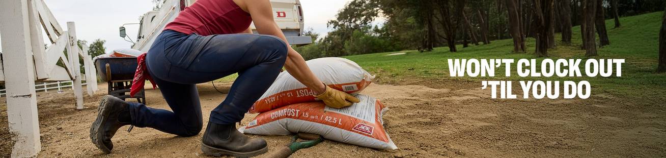 Headline: Won't Clock Out 'Til You Do,. A woman pickup up a bag of soil