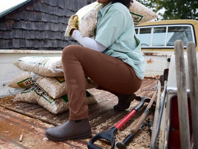 Woman crouching in brown stretchy pants.
