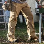 a man in fire hose shorts, digging with a shovel