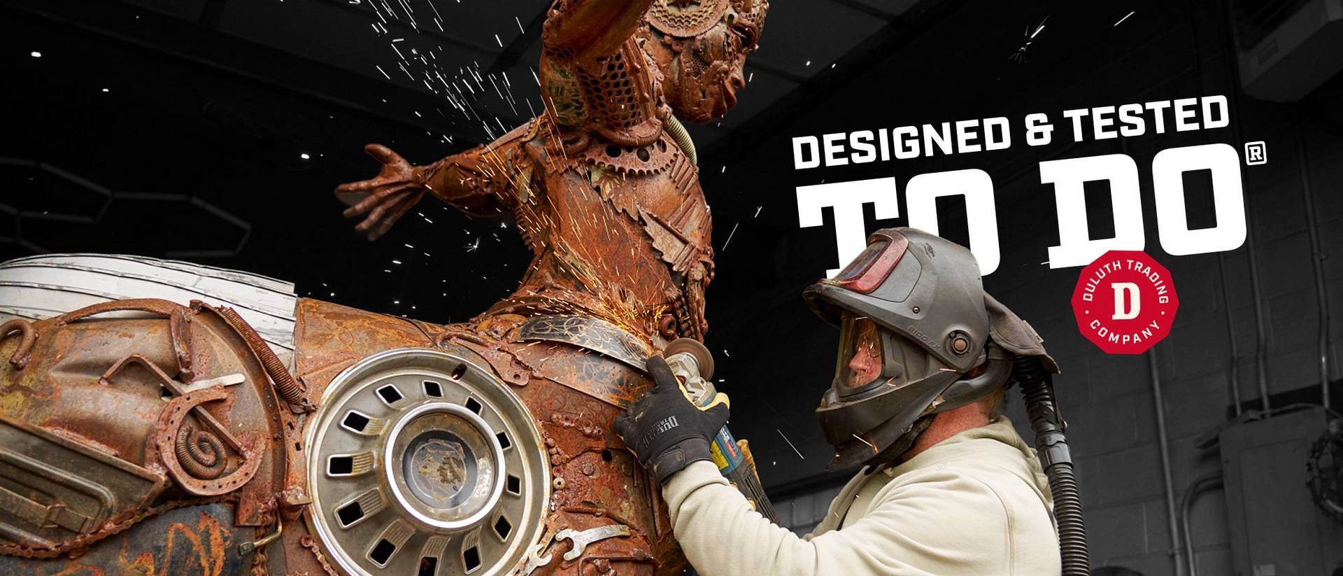 Headline: Designed & Tested To Do®. Man grinding a scrap metal sculpture.