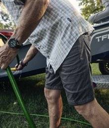 man wearing shorts; preparing boat to go out fishing