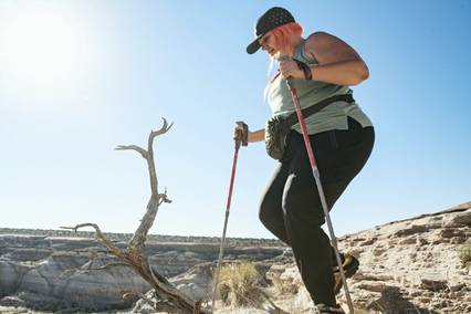 woman holding hiking poles; hiking in utah