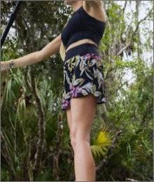 Woman wearing AKHG Lost Lake Swimwear standing on a paddle board in Florida