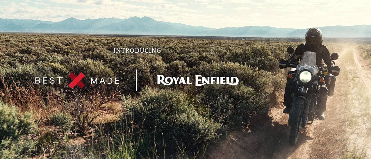 Introducing Best Made and Royal Enfield. A person rides a motorcyle on a dirt track with mountains in the distance
