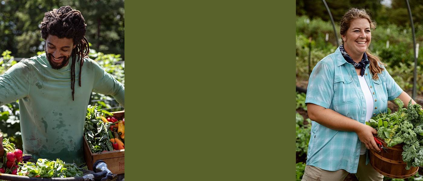 A man in a green sunperior shirt washes veggies at a table outside. A woman in a blue plaid shirt holds a bushel of vegetables.