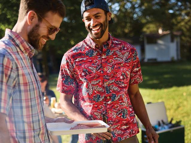 a man wearing a red shirt while grilling