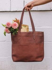A brown leather bag with flowers in it