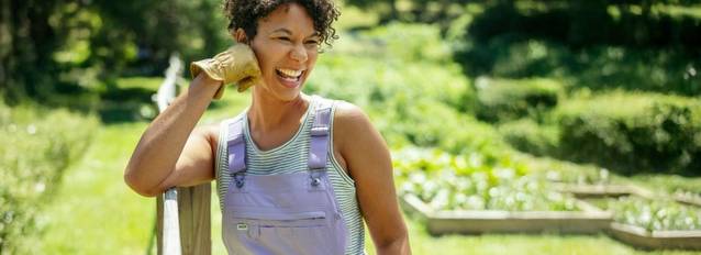Woman leaning against fence, smiling.