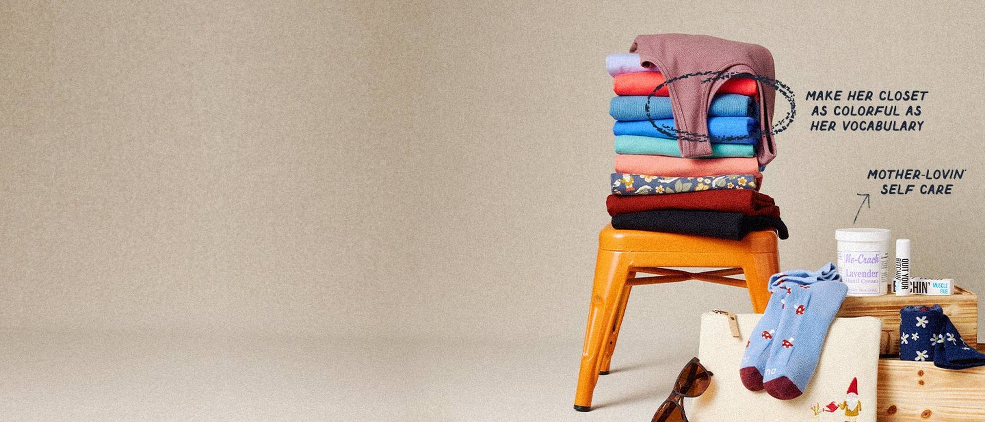 Stack of No-Yank tanks on a mini orange stool; To the left are self-care gifts, socks and sunglasses