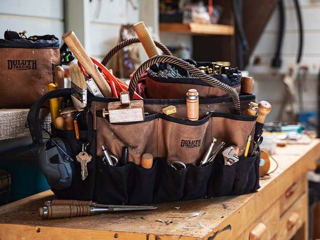 a duluth fire hose toolbag full of tools sits on a workbench
