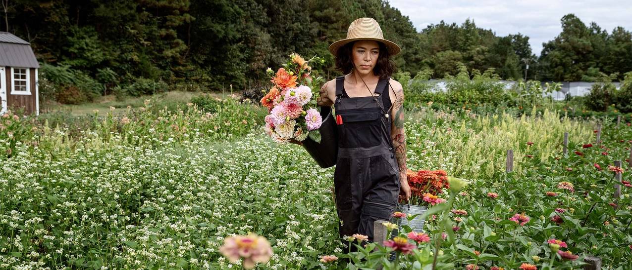 ash walks through a field of flowers growing almost as high as her hips