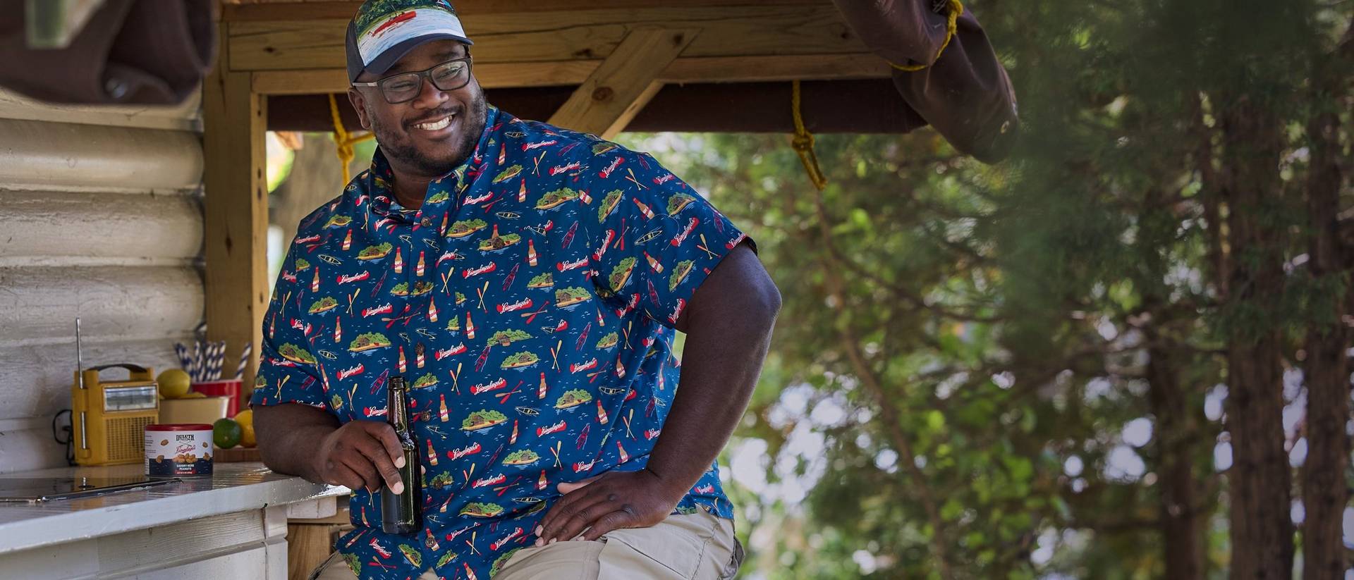 Man holding a beer bottle, smiling.