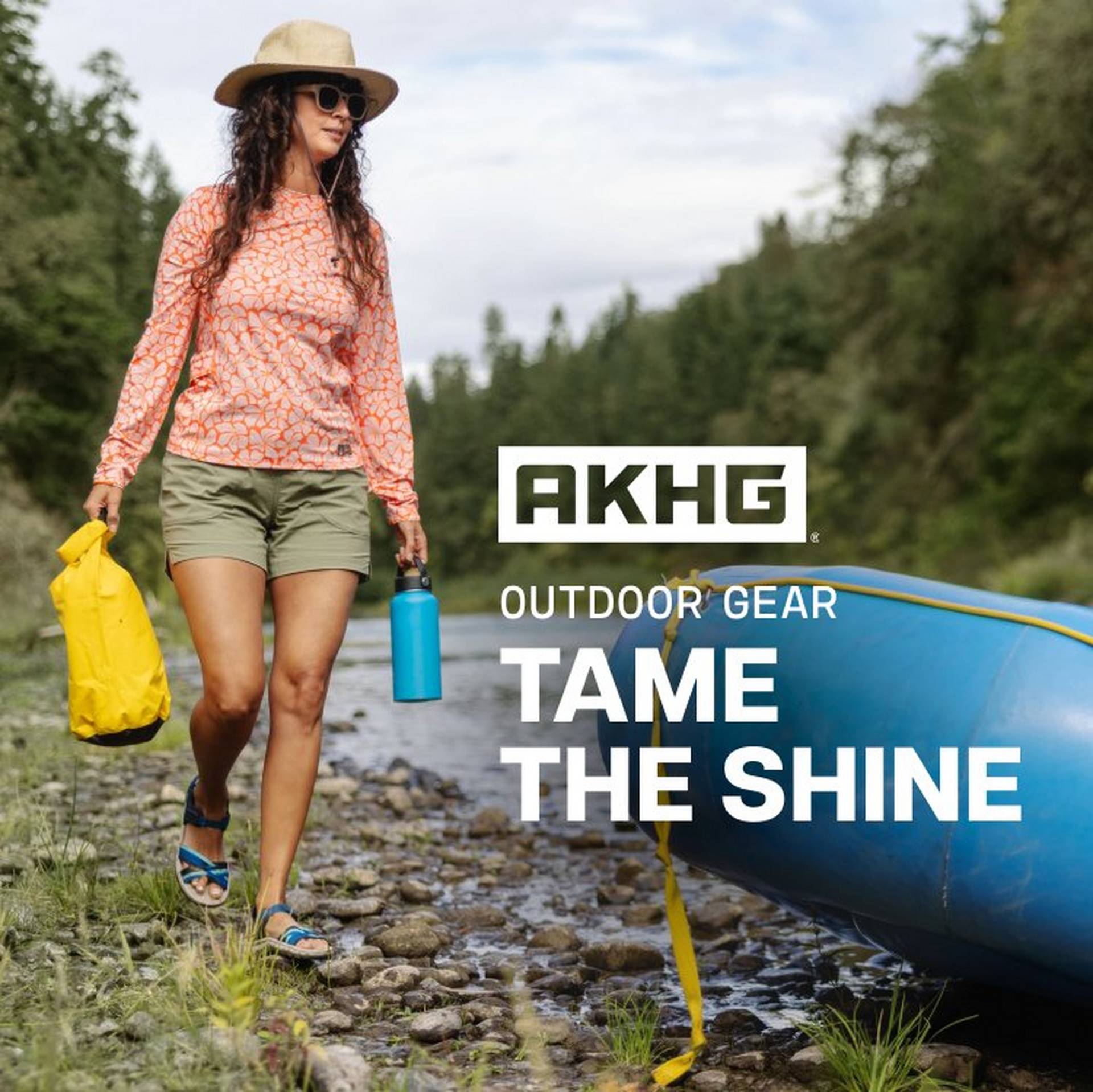 Woman wearing sun shirt, hat and shorts, walking near river.