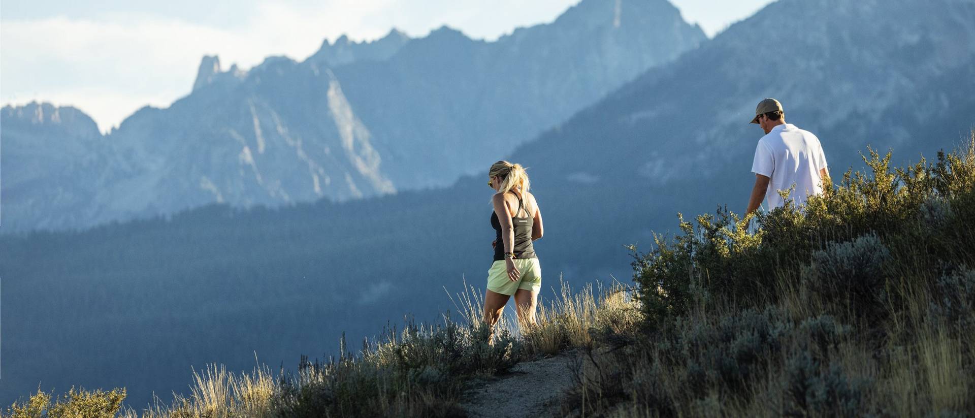A man and a woman walking in the mountains.