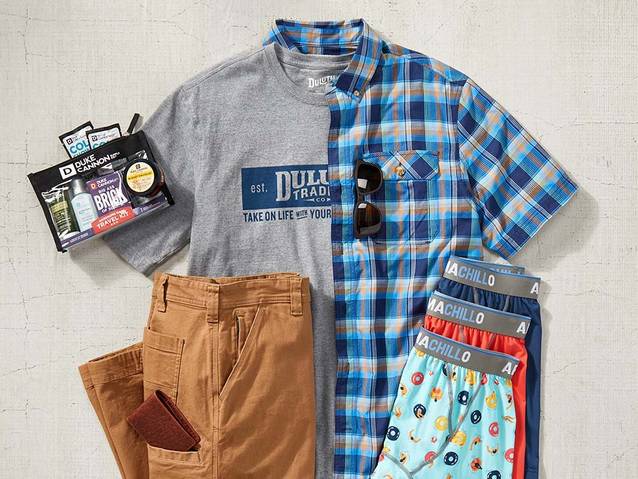 a men's duluth logo tshirt, barbecue shirt, fire hose pants, armachillo underwear and an apothecary gift set, neatly laid out on a flat surface