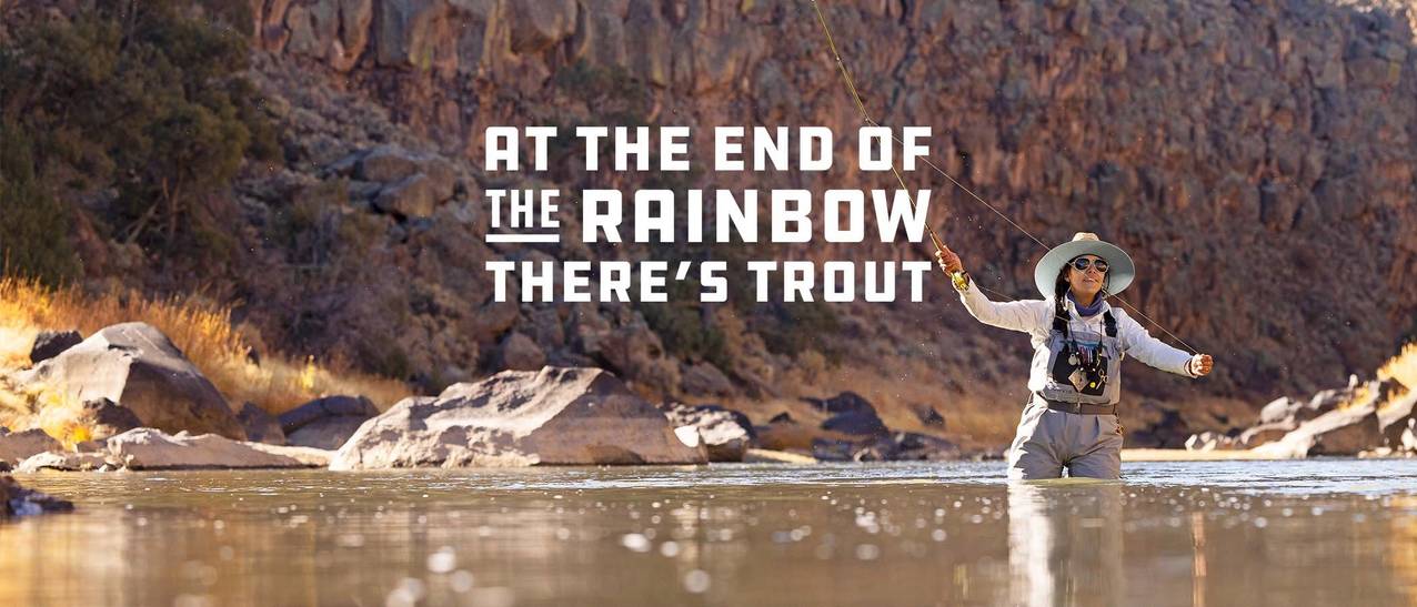 Woman stands in water fly fishing