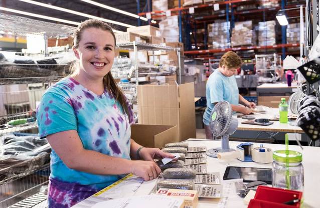 Woman in a warehouse packing orders