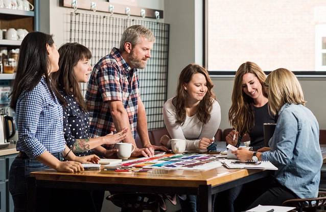 People standing around a table discussing fabrics