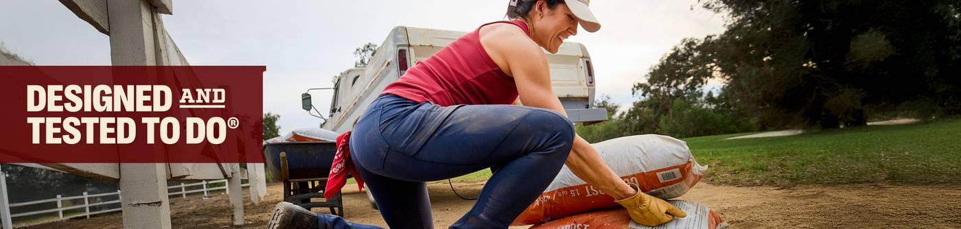Woman picking up bags of compost.
