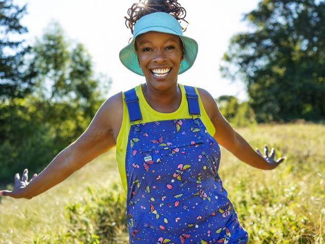 Woman wearing overalls with a bug pattern.