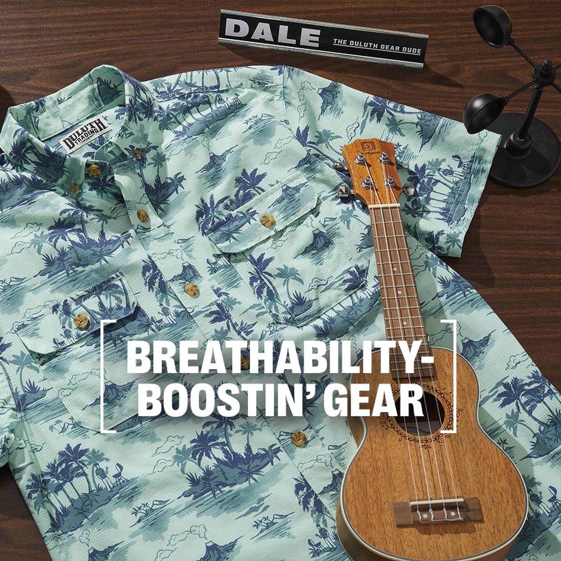 Shirt, phone and ukulele on table.