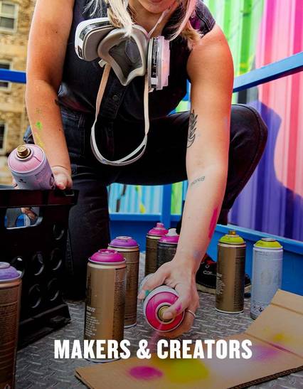 woman using spray paint on cardboard